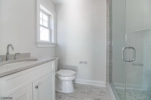 a bathroom with a granite countertop toilet a sink and a mirror