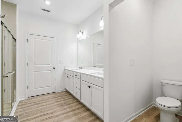 a spacious bathroom with a granite countertop sink toilet and shower