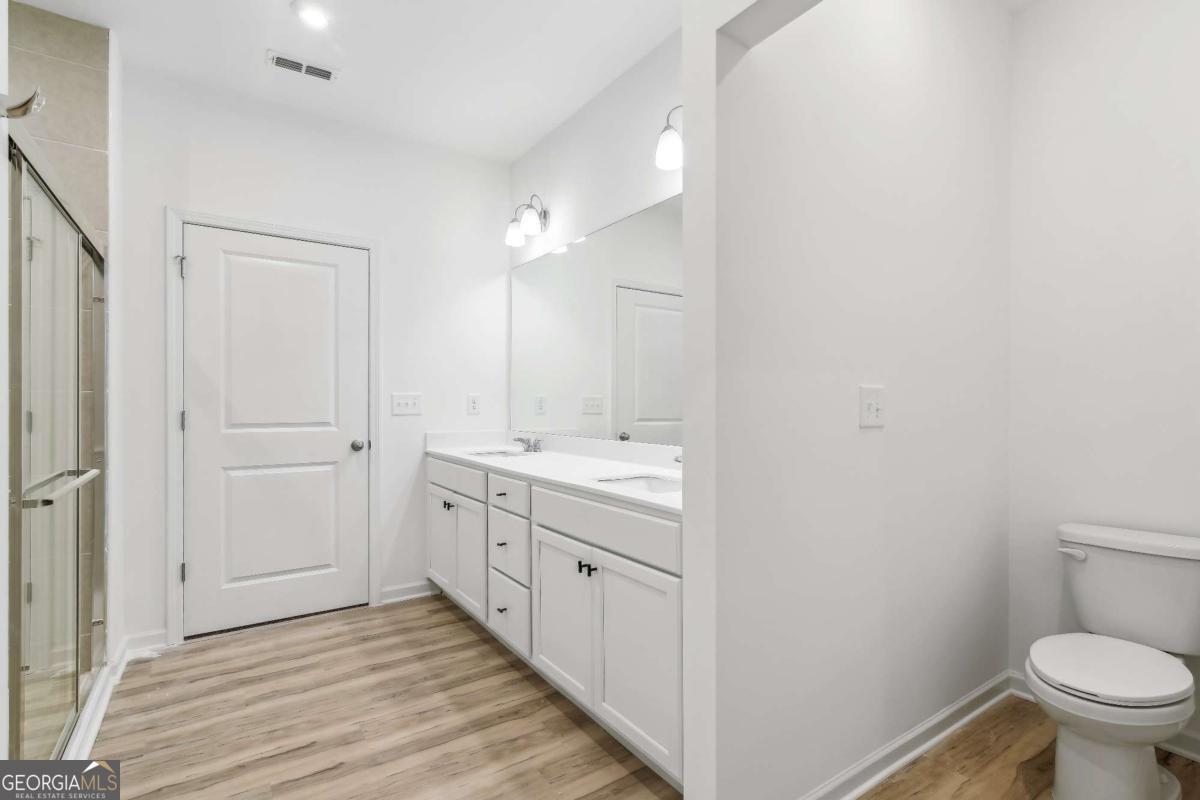 1545 Salinger Court, Unit 1545 Stockbridge, GA 30281 - Photo 11 of 26 a spacious bathroom with a granite countertop sink toilet and shower