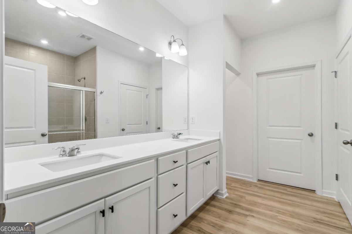 1545 Salinger Court, Unit 1545 Stockbridge, GA 30281 - Photo 13 of 26 a spacious bathroom with a double vanity sink mirror and