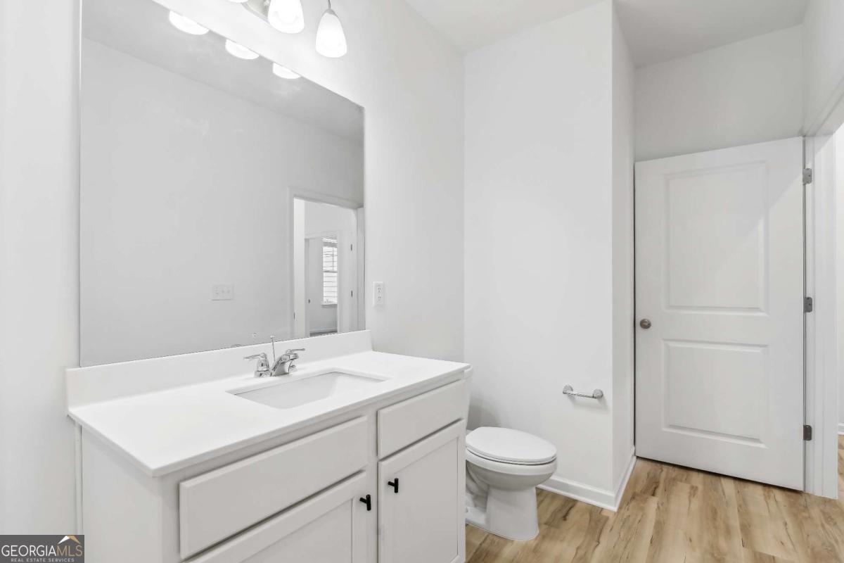 1545 Salinger Court, Unit 1545 Stockbridge, GA 30281 - Photo 18 of 26 a bathroom with a sink a toilet and a mirror