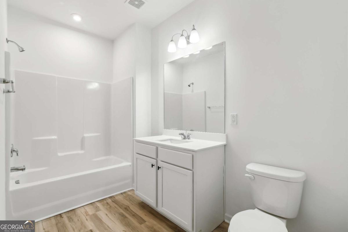 1545 Salinger Court, Unit 1545 Stockbridge, GA 30281 - Photo 19 of 26 a bathroom with a sink a toilet and bathtub