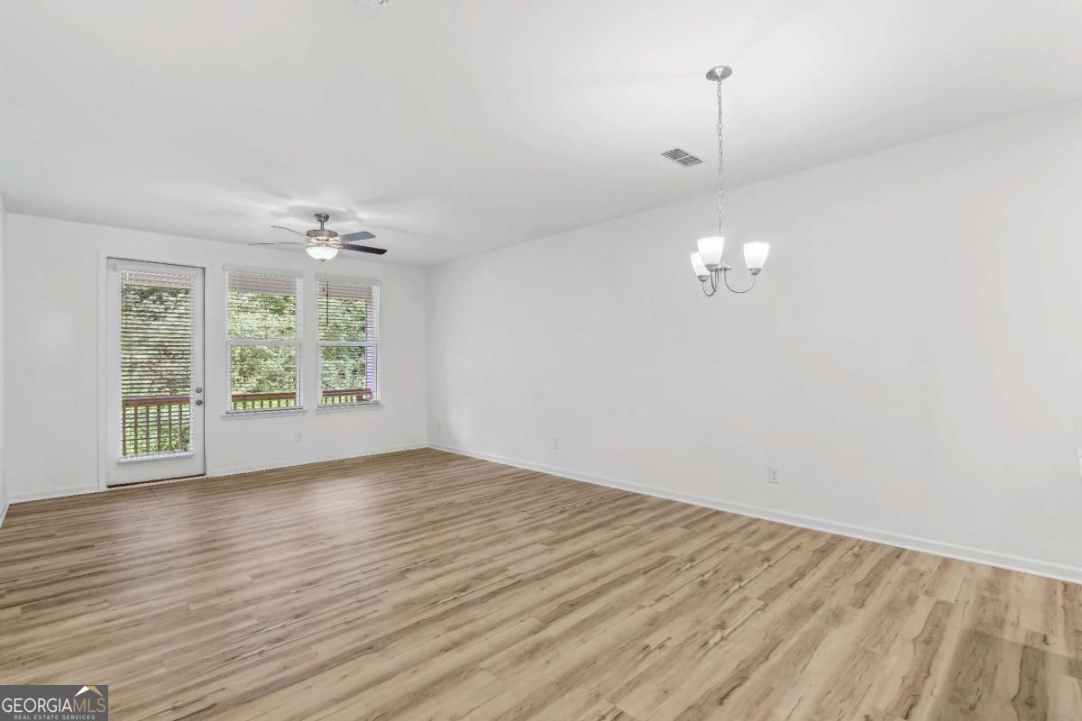 1545 Salinger Court, Unit 1545 Stockbridge, GA 30281 - Photo 2 of 26 wooden floor in an empty room with a window