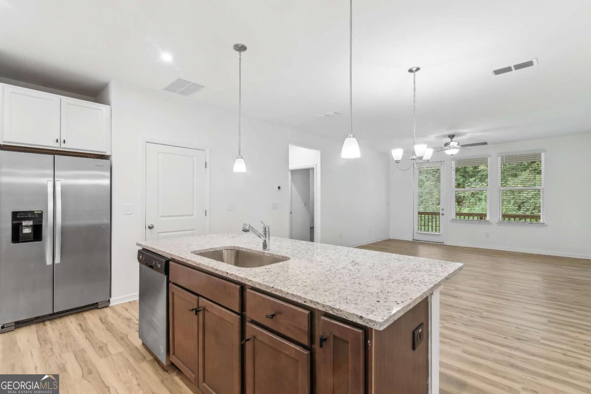 1545 Salinger Court, Unit 1545 Stockbridge, GA 30281 - Photo 6 of 26 a kitchen with a sink chandelier and refrigerator