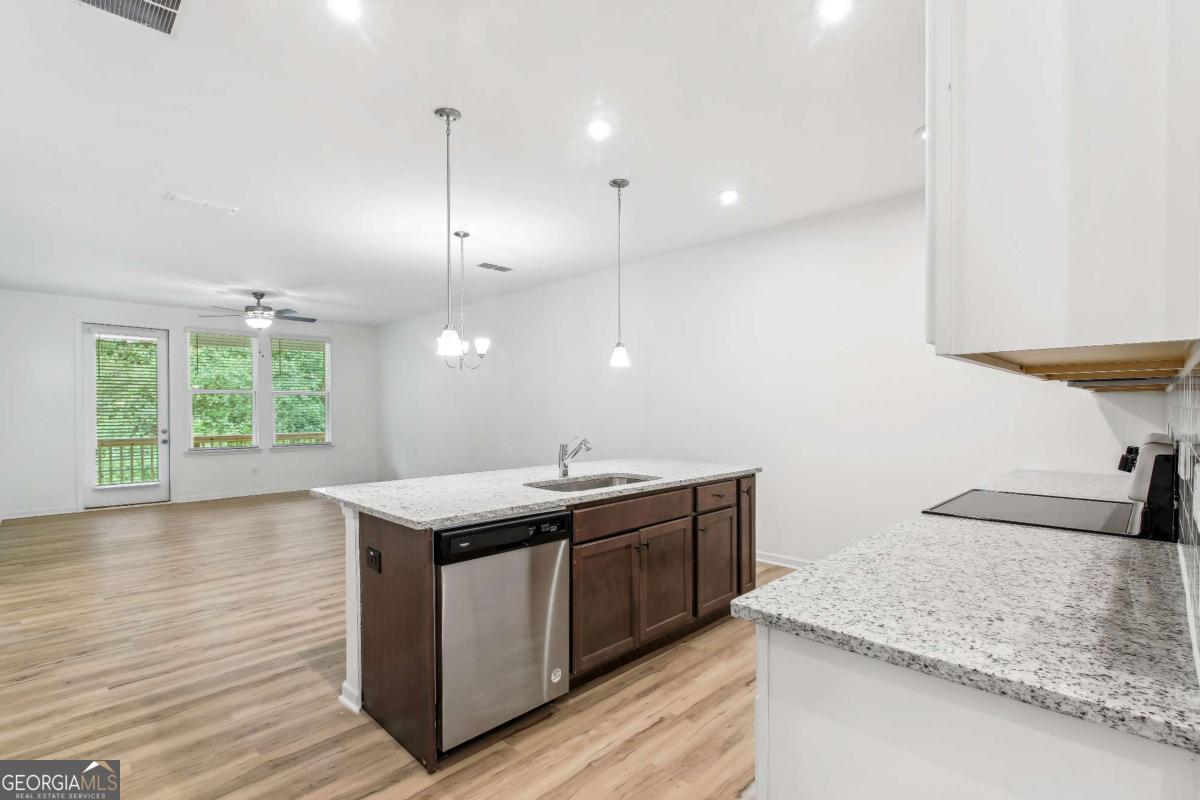 1545 Salinger Court, Unit 1545 Stockbridge, GA 30281 - Photo 7 of 26 a kitchen with stainless steel appliances granite countertop a sink a stove and a wooden floors