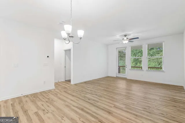 a view of a room with wooden floor and a ceiling fan