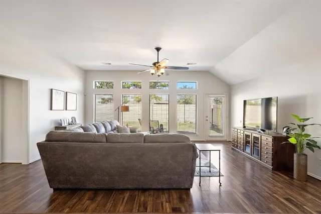 a living room with furniture and wooden floor