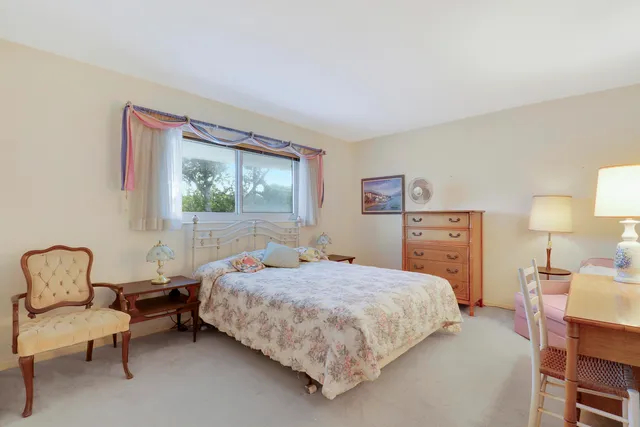 a bedroom with a bed chair and window