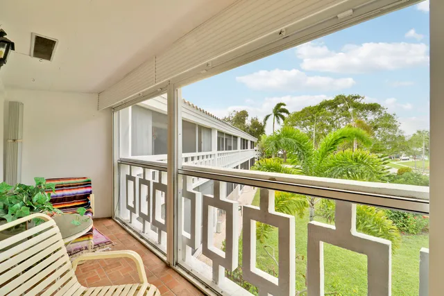 a balcony with wooden floor table and chairs
