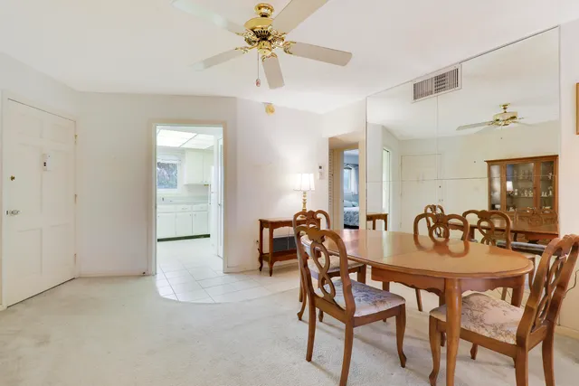 a view of a dining room with furniture and a chandelier fan