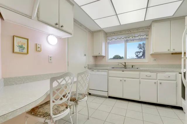 a kitchen with granite countertop white cabinets and white appliances