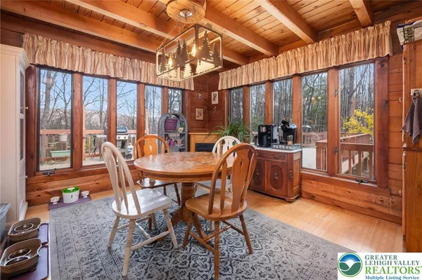 a dining room with furniture water view and a floor to ceiling window