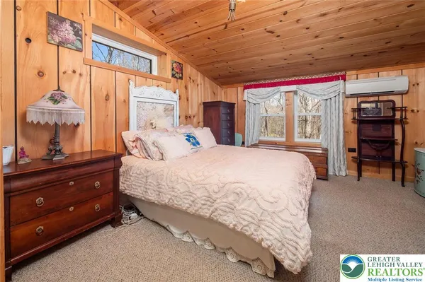 a bedroom with a bed and large windows