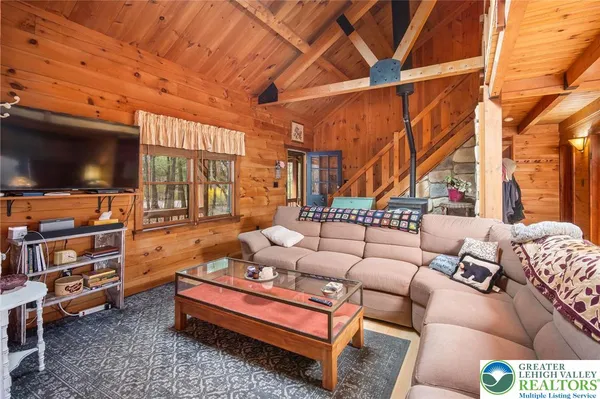 a living room with furniture a flat screen tv and a window