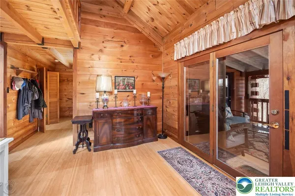 a room with lots of wooden furniture and glass door