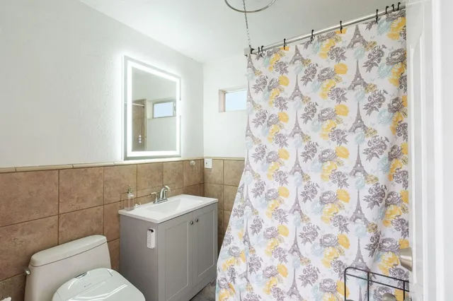 a white toilet sitting next to a bathroom sink