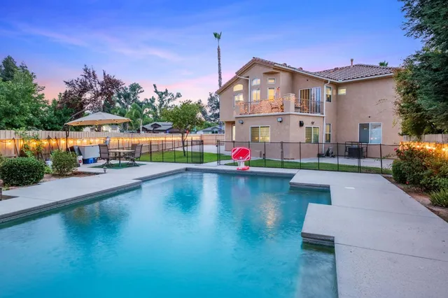 a view of a house with swimming pool and sitting area