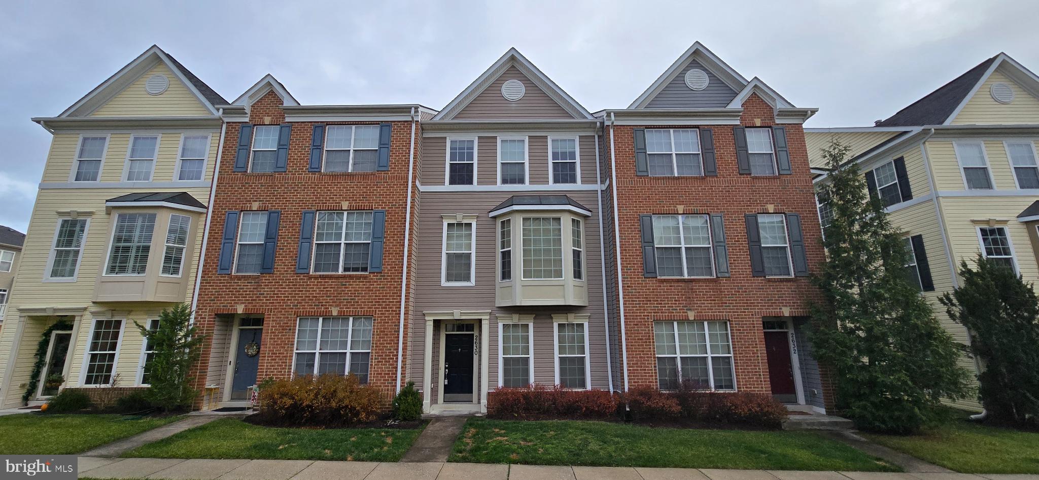 a front view of residential houses with yard and green space