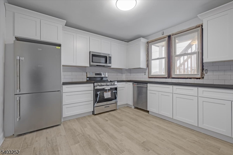 120 High Street, Unit 2 Newton, NJ 07860 - Photo 2 of 7 a kitchen with white cabinets and stainless steel appliances
