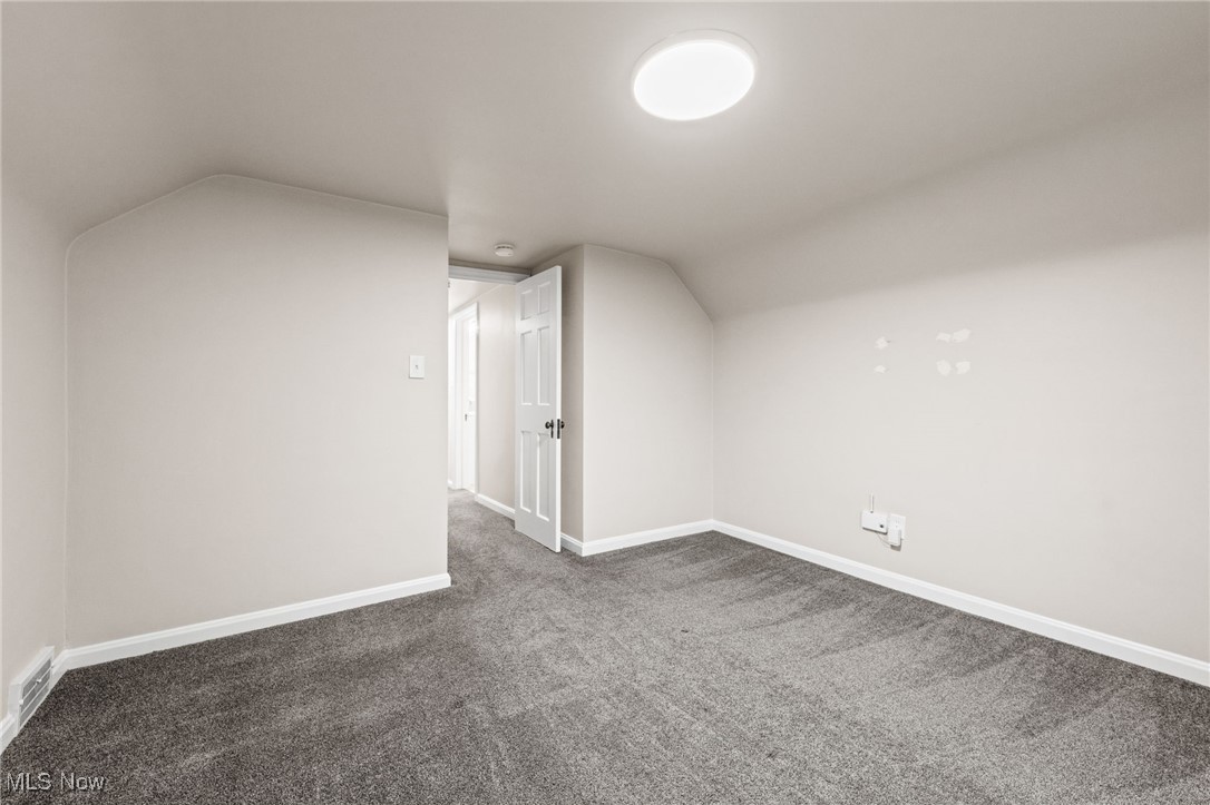 3662 Riedham Road Cleveland, OH 44120 - Photo 22 of 30 Bonus room with dark colored carpet and lofted ceiling