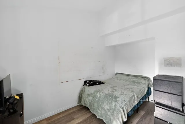 a bedroom with a bed and wooden floor