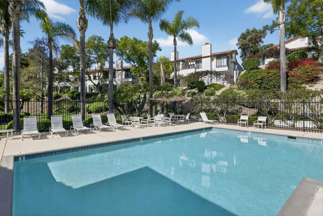 a view of swimming pool with outdoor seating and house in the background