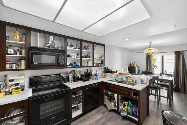 a kitchen that has a lot of cabinets in it and wooden floors