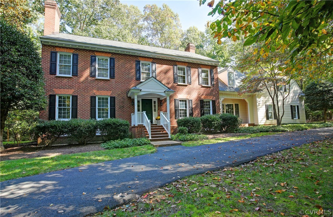 a front view of a house with a yard and potted plants