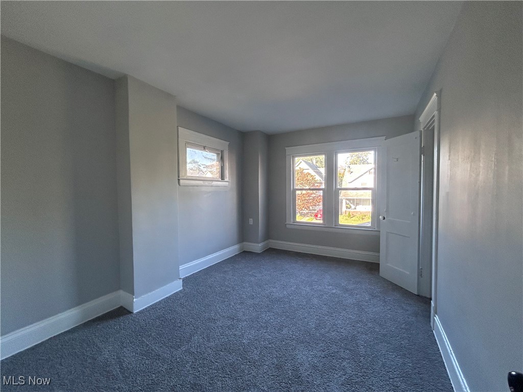1229 Melbourne Road Cleveland, OH 44112 - Photo 16 of 22 Unfurnished room with dark colored carpet and baseboards