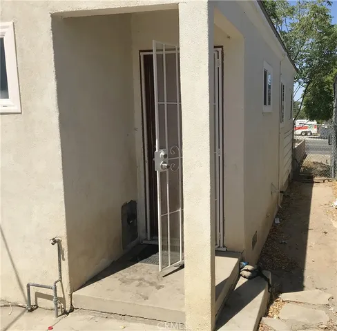 a backyard of a house with large trees and outdoor seating