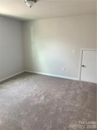 a view of an empty room and chandelier fan