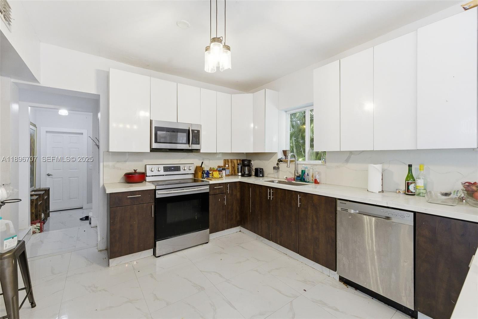 401 Southwest 28th Road Miami, FL 33129 - Photo 13 of 45 a kitchen with kitchen island granite countertop a stove sink microwave and cabinets