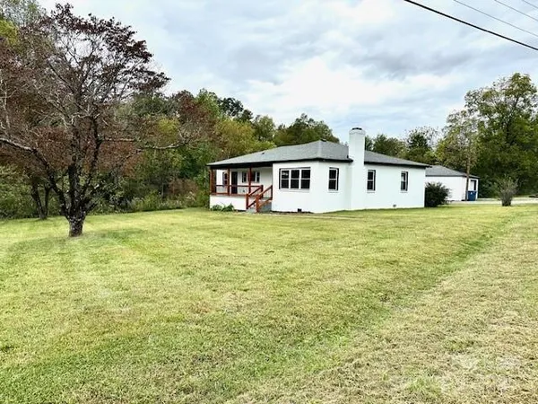 a view of a house with yard and sitting area