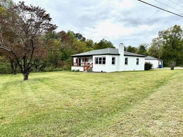 a view of a house with yard and sitting area