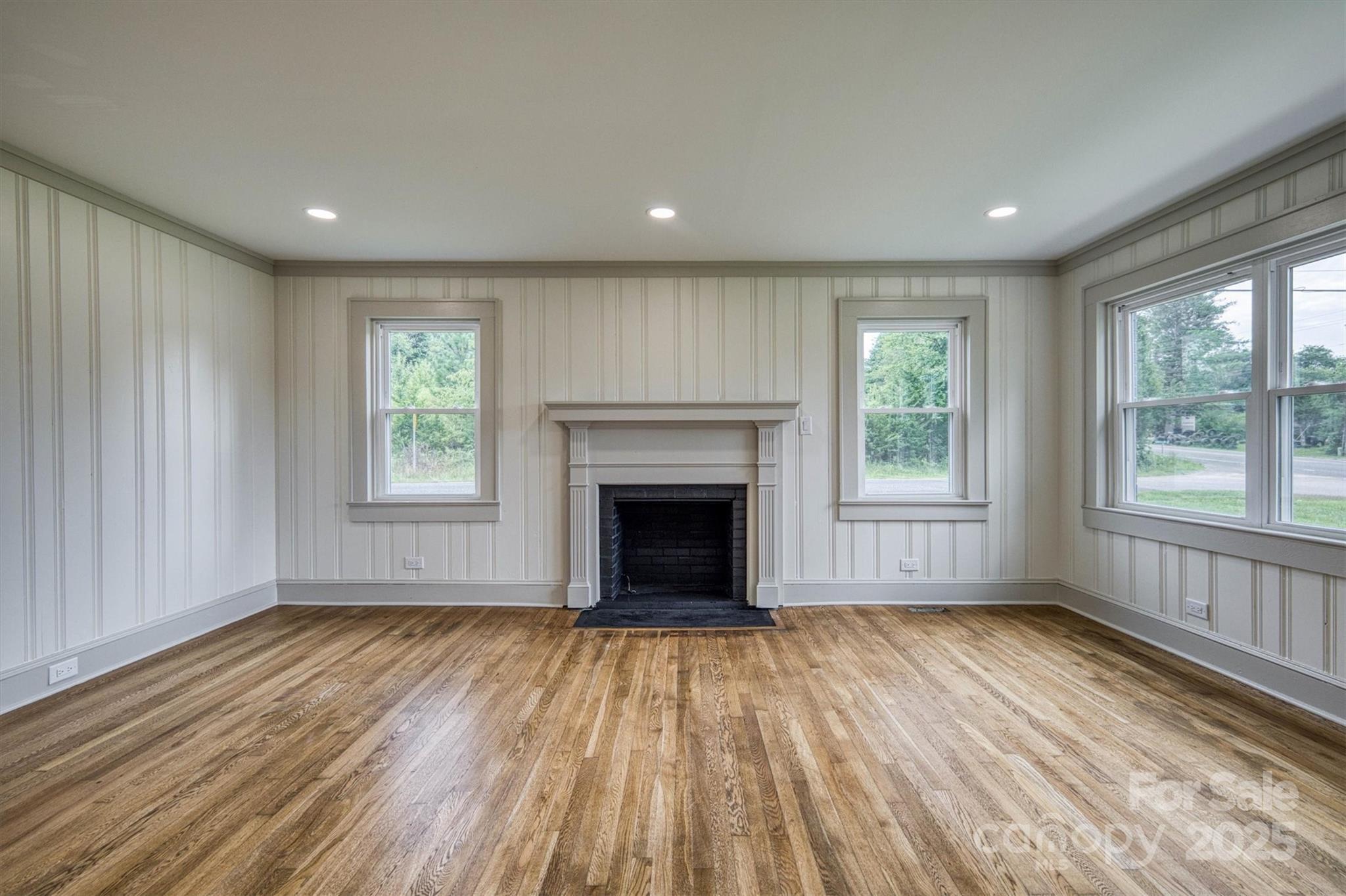 2775 Snipes Street Morganton, NC 28655 - Photo 13 of 28 a view of an empty room with wooden floor windows and a fireplace