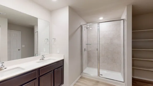 a bathroom with a shower sink vanity and mirror