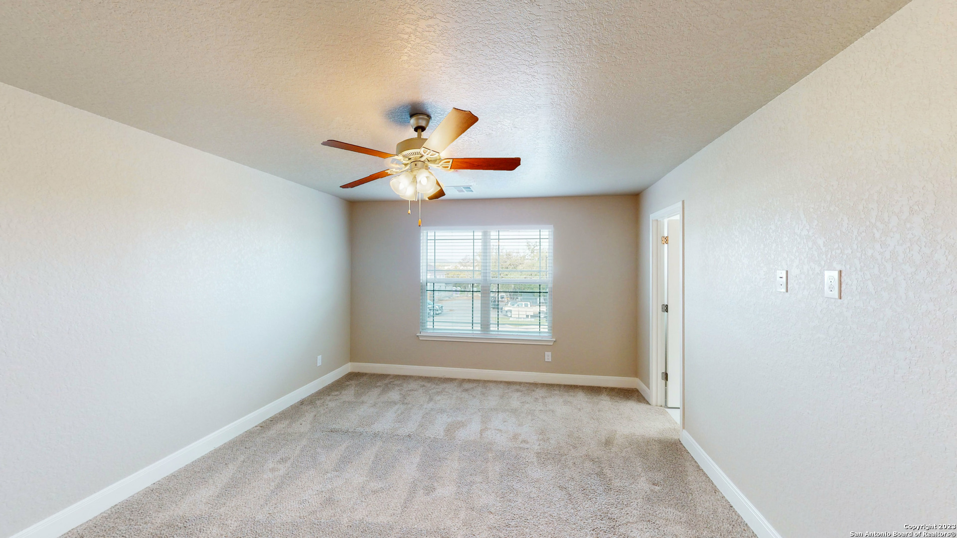 146 Magnolia Circle Boerne, TX 78006 - Photo 11 of 20 an empty room with a window and a chandelier fan