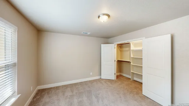 an empty room with a fireplace and windows
