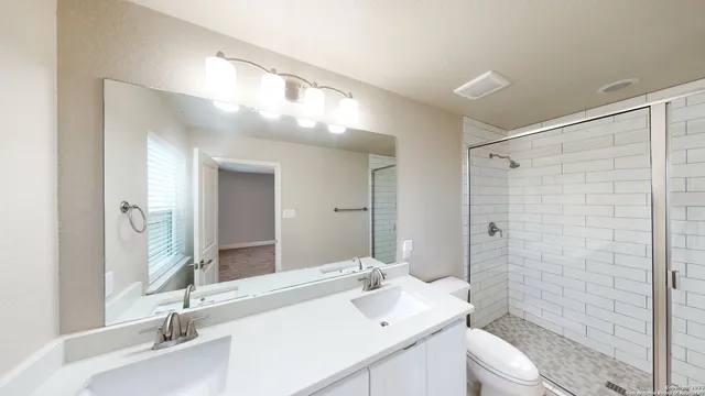 a bathroom with a sink a toilet and shower