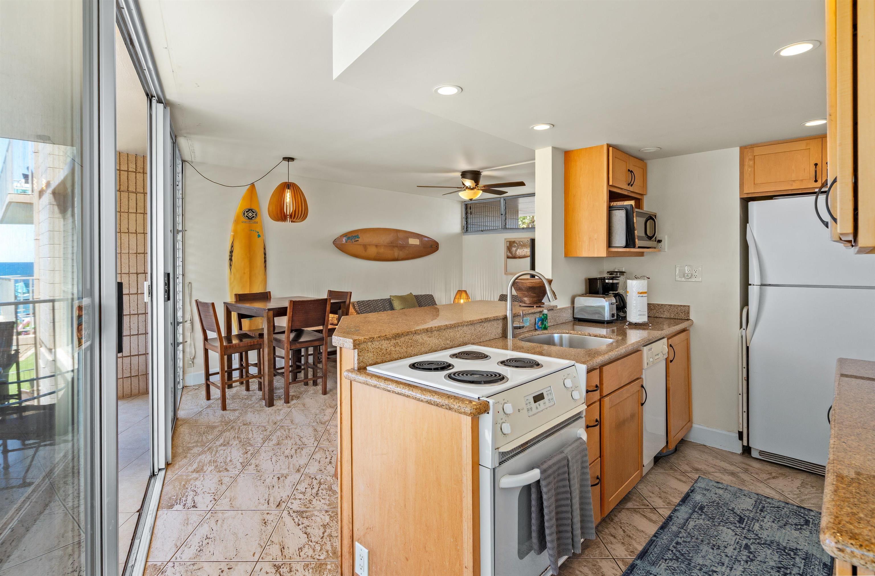 2450 South Kihei Road, Unit 301 Kihei, HI 96753 - Photo 4 of 35 a kitchen with a sink a stove and a refrigerator