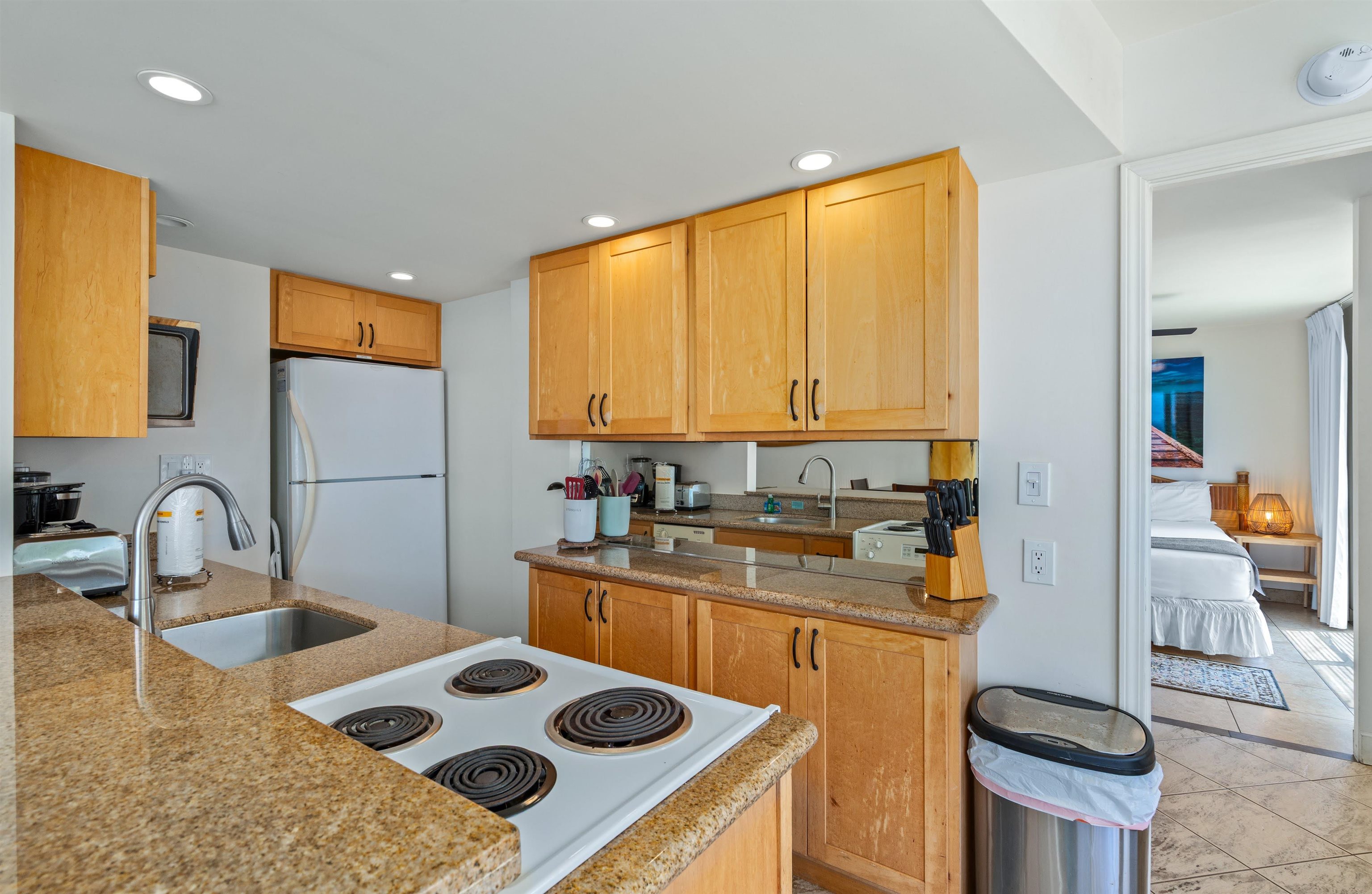 2450 South Kihei Road, Unit 301 Kihei, HI 96753 - Photo 5 of 35 a kitchen with a stove a sink and a refrigerator