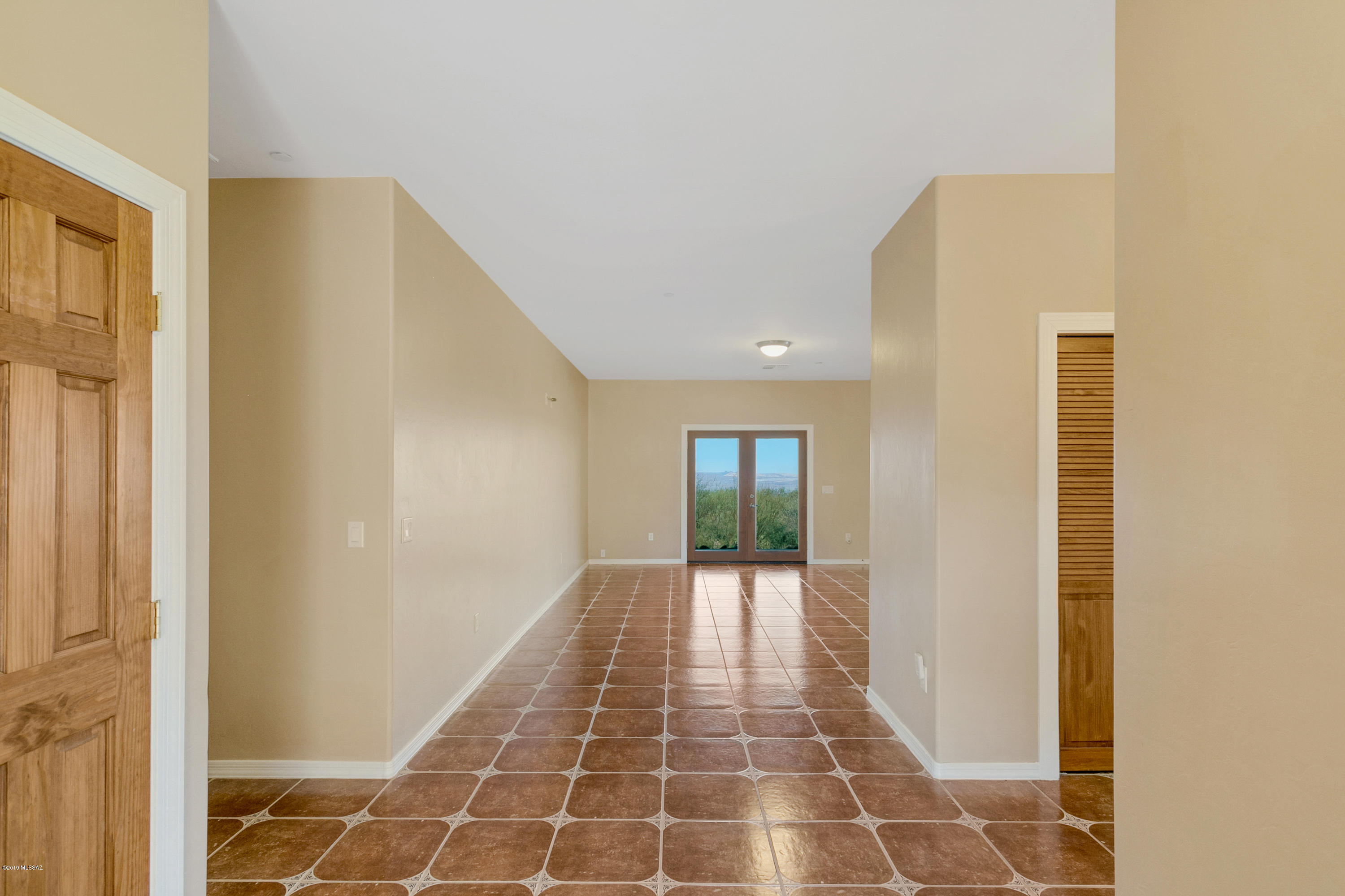 21960 South Helvetia Road Sahuarita, AZ 85629 - Photo 23 of 29 a view of a hallway with wooden floor and a bathroom