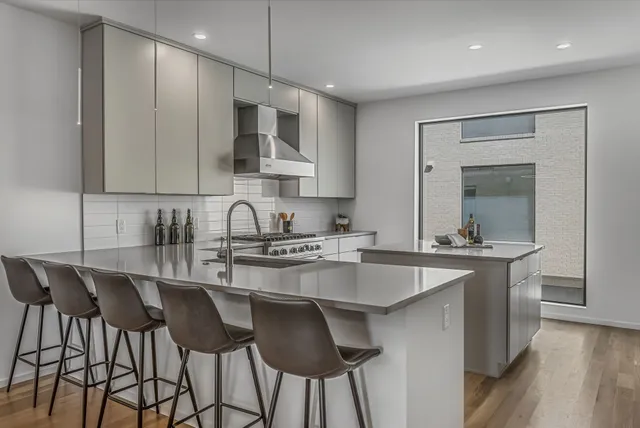 a kitchen with stainless steel appliances granite countertop a sink a stove and a microwave