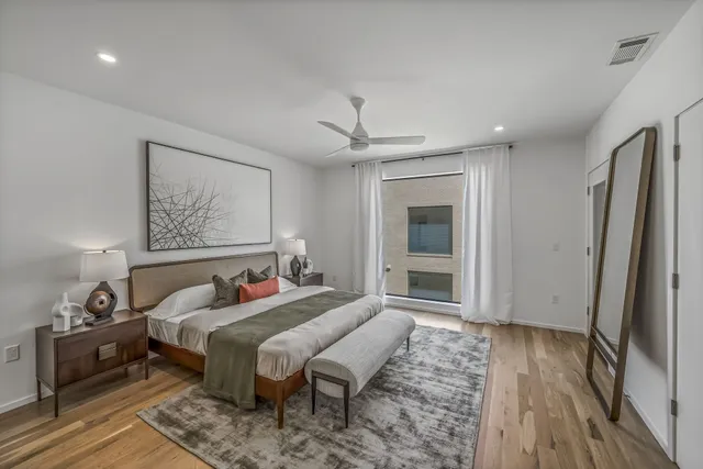 a bedroom with bed and wooden floor