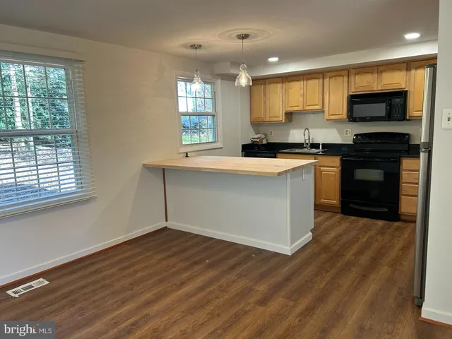 a kitchen with stainless steel appliances a stove top oven a sink dishwasher a refrigerator and a microwave