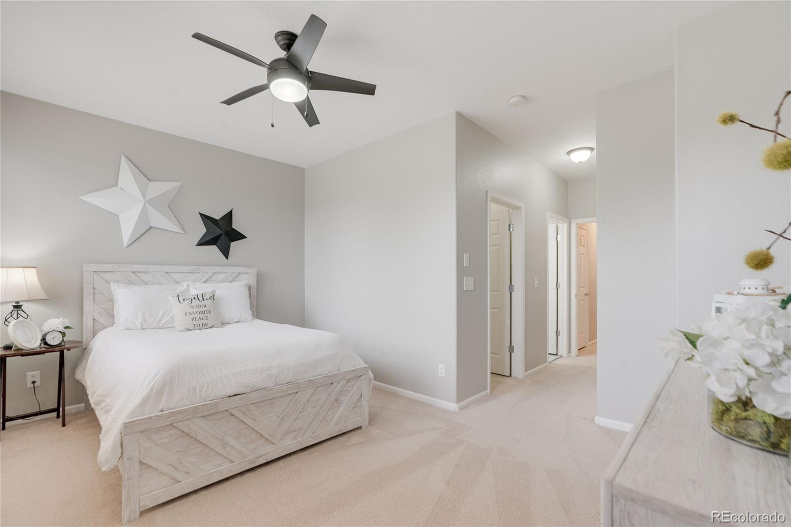 5392 Allison Street Arvada, CO 80002 - Photo 18 of 47 a bedroom with a bed and a chandelier fan