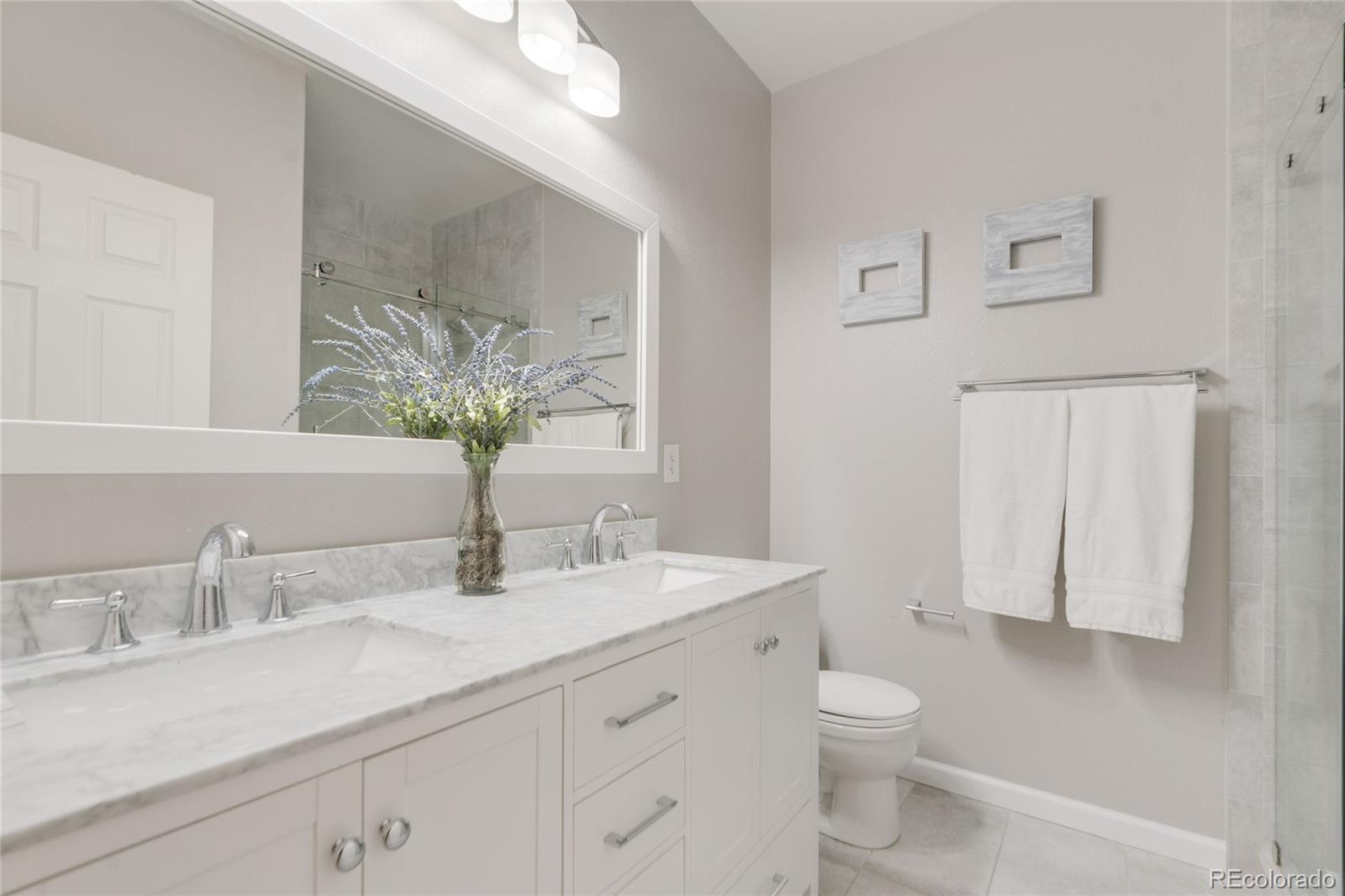 5392 Allison Street Arvada, CO 80002 - Photo 19 of 47 a bathroom with a granite countertop sink a toilet and a mirror