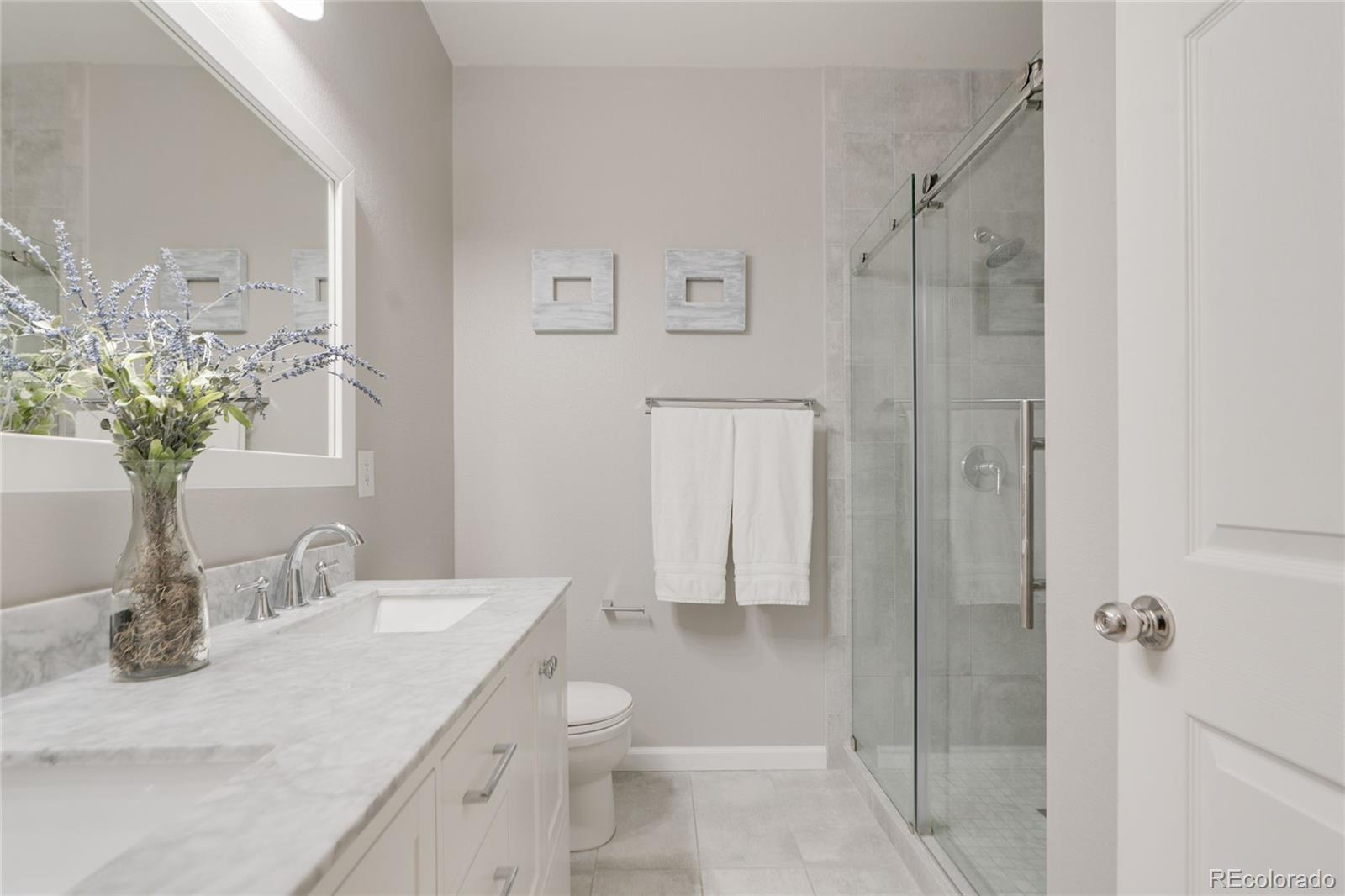 5392 Allison Street Arvada, CO 80002 - Photo 20 of 47 a bathroom with a granite countertop sink a toilet and shower