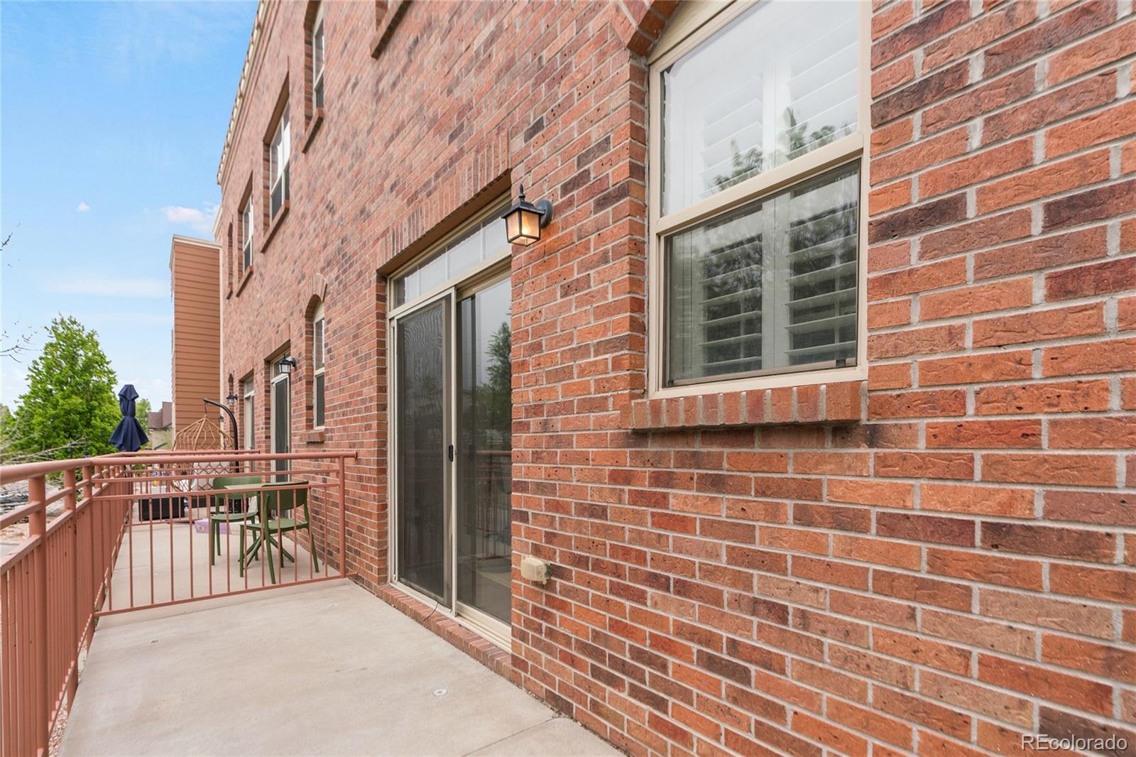 5392 Allison Street Arvada, CO 80002 - Photo 29 of 47 a view of a brick wall with a bench in front of building