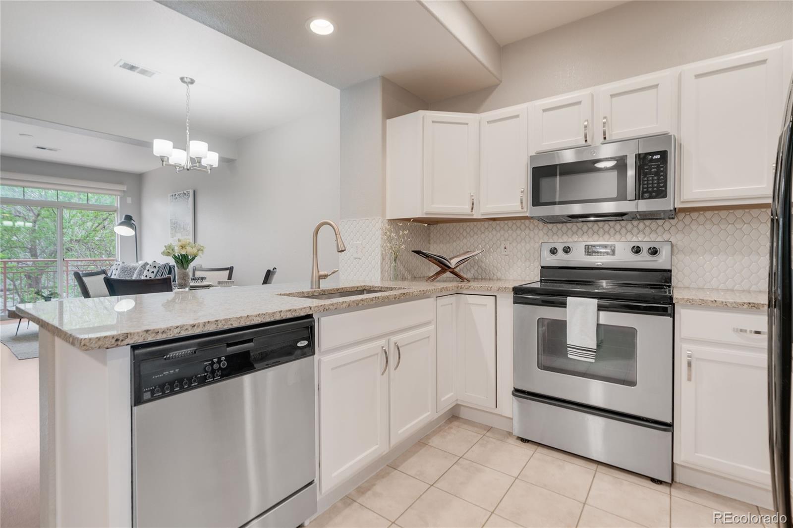 5392 Allison Street Arvada, CO 80002 - Photo 5 of 47 a kitchen with a sink stove and microwave